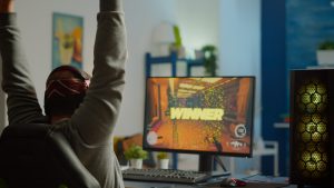 Back shot of happy man gamer wining first person shooter video game